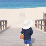 Child walks towards sunny beach